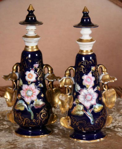 Pr. Cobalt Floral Old Paris Perfumes: Pr. Cobalt Floral Old Paris Perfumes. Beautifu pink & white glowers molded on a cobalt background w/ gilt trim and giold painted leafy handles on the sides with stoppers. About 13" high; chip under st