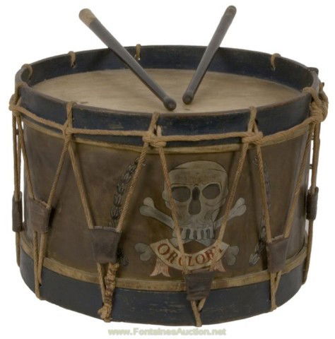 Queens Lancer Drum: Metal bodied drum 10.5" high by 15.5" wide. Rope tensioned with triangular leather keepers. Body of the drum is brass that has attained a dark patina. A skull and crossed bones has been painted on wit