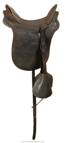 U.S. ARTILLERY DRIVERS SADDLE W/ SHIELD DECORATIO: Has McClellan type seat. Comes with 12"H x 16"H leg guards and wood stirrups covered with leather. Leather is crackled from age and could use a cleaning and treatment. A nice antique saddle.
