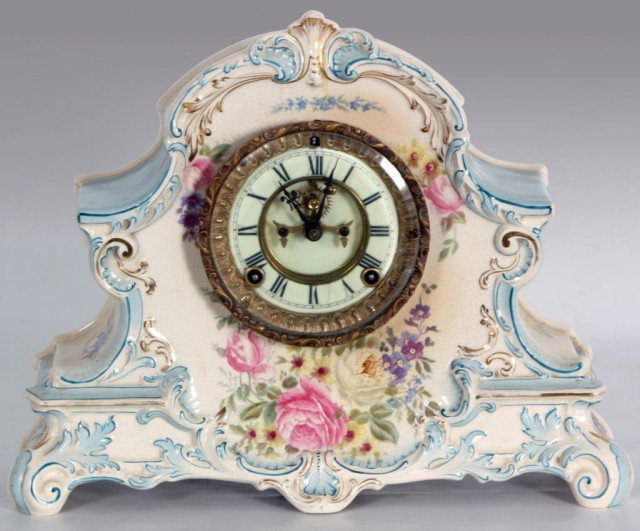 Ansonia Royal Bonn China Clock: Ansonia Royal Bonn China Clock. White porcelain with pale blue and gilt leaf trim, decorated around the bezel with pink and white roses and violet flowers; Signed Royal Bonn. Porcelain chapter ring wi