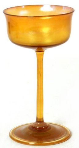 L.C. Tiffany Favrile Iridescent Goblet: L.C. Tiffany Favrile Iridescent Goblet. A cylindrical cup with a flared rim, long thin stem applied to a round foot. Gold with a deep red and silver iridescent finish. In excellent condition with no c