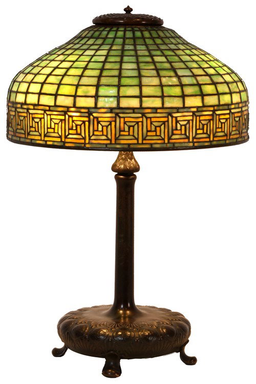 Tiffany Studios Greek Key Table Lamp: Tiffany Studios Greek Key Table Lamp. The 18 in. serpentine leaded shade has a green brick geometric top and a lower 2.5 in border with a golden Greek Key pattern, signed on a metal tag - Tiffany Stud