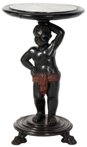 Marble Top Blackamore Figural Stand: Marble Top Blackamore Figural Stand. Figural carved ebony figure wears a painted red garment cinched at the waist, blown glass beaded eyes; holds a marble top tray over his head, standing on a round p