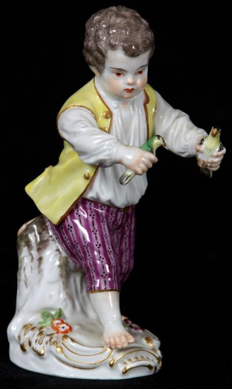 Meissen Painted Figure Of A Boy: Meissen Painted Figure Of A Boy. The boy is running with a parakeet in each hand, he has brown curly hair, a yellow vest over a white shirt and embroidered purple trousers. Signed under glaze Meissen