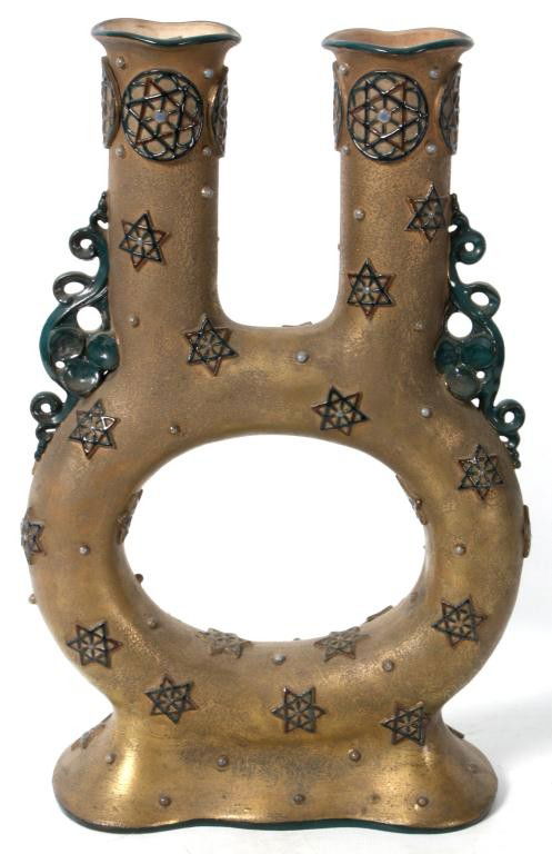Amphora Judaic Double Spout Vessel: Amphora Judaic Double Spout Vessel. Vase has a tubular oval form with a ruffled foot and a pair of cylindrical spouts with a dore colored finish. Decorated with teal green scrolling handles, Star of D