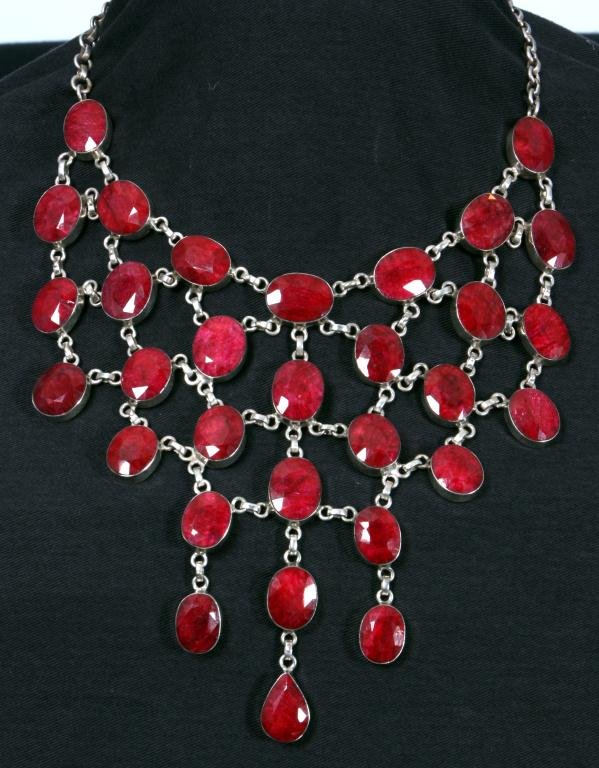 Approx. 150 Carat Raw Ruby Necklace: Approx. 150 Carat Raw Ruby Necklace. Containing 31 oval bezel set raw rubies and one pear shaped ruby totaling about 150 carats, in a sterling silver chain link necklace.