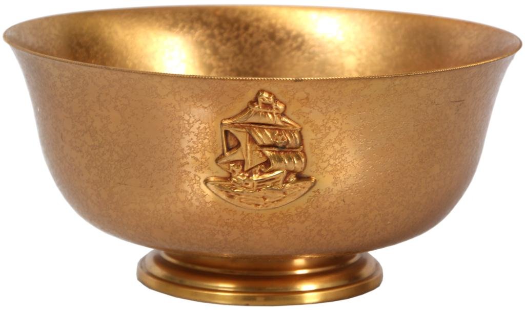 Tiffany Furnaces Dore Bowl: Tiffany Furnaces Dore Bowl. Fine bronze bowl stands on a round foot and has a flared rim; nice gold dore finish and molded plaque of a ship on the front. Signed on the bottom Louis C. Tiffany Furnaces
