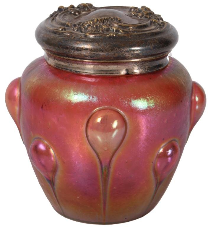 Austrian Art Glass Humidor: Austran Art Glass Humidor. Red iridescent oil spot art glass vase with alternating long and short inverted teardrop pattern; has a repousse silver plated lid with floral design. Few minor chips in the