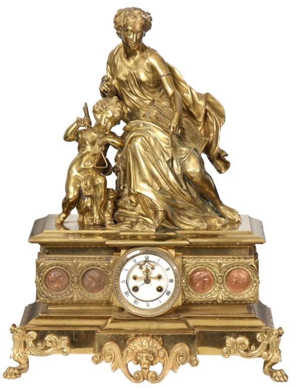 French Figural Bronze Mantle Clock: French Figural Bronze Mantle Clock. The figure on top depicts an allegorical scene of music, a seated woman wearing a long robe holds a harp in her lap, beside her is a winged putti, seated and leanin