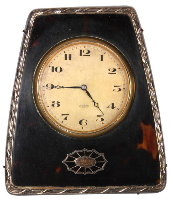 English Sterling & Tortoise Clock: English Sterling & Tortoise Clock. Pyramidal desk clock has a tortoise shell front with sterling frame and inlaid plaque on the front; dial has Arabic numbers and open diamond hands, 8 day spring driv