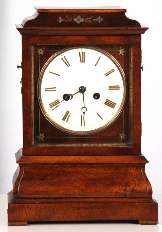 English Mahogany Mantle Clock: English Mahogany Mantle Clock. Mahogany case has elegant brass inlays, 6 in. dial with brown Roman hour numerals and open moon hands; brass movement has a recoil escapement and count-wheel strike mech