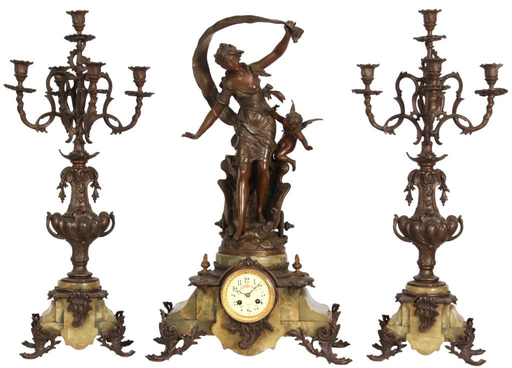 3 Pc. French Figural Clock Set: 3 Pc. French Figural Clock Set. Green onyx base with fancy feet and mounts; white metal figural top after Aug. Moreau titled - Le Char de Jeunesse – The Chariot of Youth, depicts a woman standing in