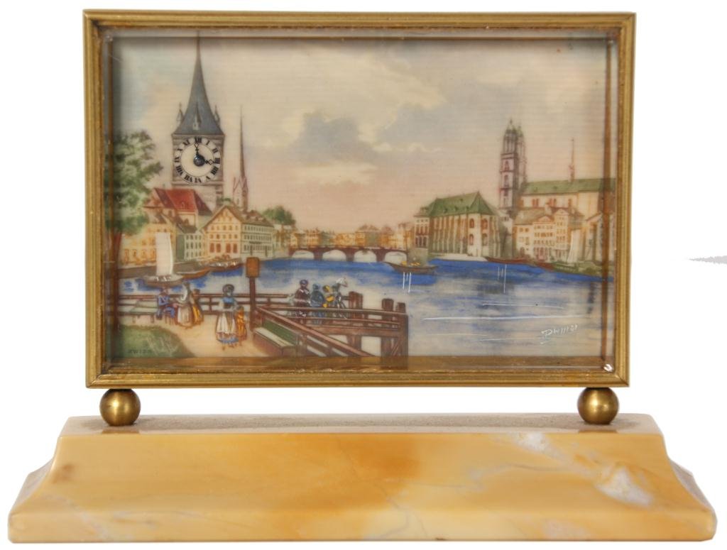 Swiss Painted Ivory Desk Clock: Swiss Painted Ivory Desk Clock. 3.5 in. x 2.5 in. painted ivory dial titled L’Embarcadere, depicts a pier along a waterway with buildings in the background, the large tower in the back has a functio
