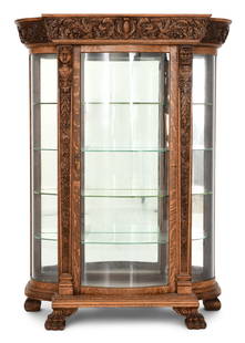American Carved Oak Figural China Cabinet: American Carved Oak Figural China Cabinetlate 19th centuryelaborately carved with a cartouche shield, filigree, maiden bust, mythical bust and claw feet73 x 50 x 21 inchesProvenance: Private Collectio