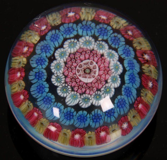 Baccarat Caned Paperweight: Baccarat Caned Paperweight. A round form with a concave bottom, decorated with 5 rows of colorful caning. Signed on the bottom with Baccarat logo. In good condition with no cracks, chips, breaks or br