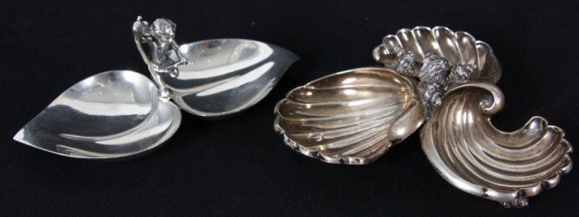 2 Fancy Silver Table Salts: 2 Fancy Silver Table Salts. Signed Tiffany & Co. Makers Sterling 23634, The first has 2 individual leaf shaped bowls centered with a standing figure of a winged cupid; the second piece has 3 seashell 