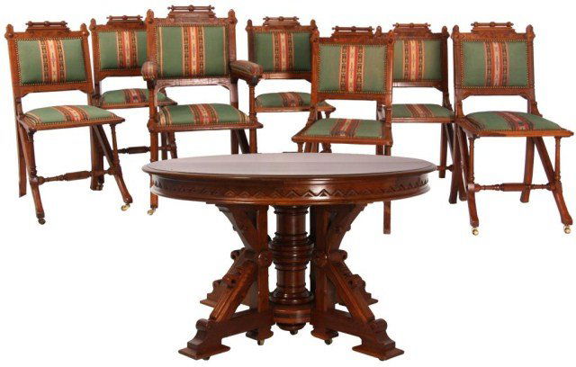 Carved Aesthetic Walnut Dining Table & Chairs: Carved Aesthetic Walnut Dining Table & Chairs. 48 in. round Aesthetic style table has a carved apron and carved base with large turned center leg. Includes 15 matching chairs including 3 armchairs; tu