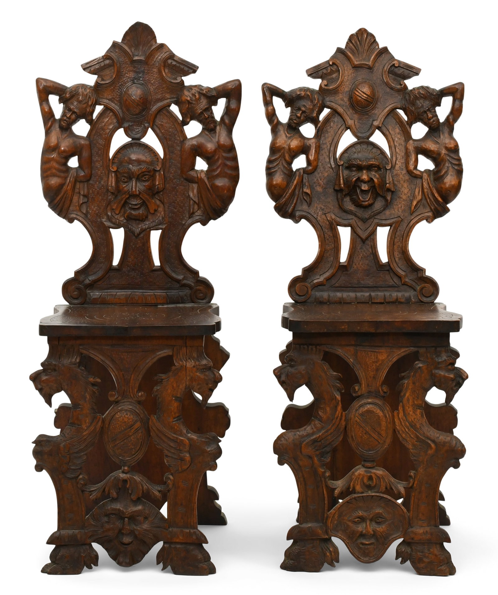 Pair of Italian Figural Carved Hall Chairs: Pair of Italian Figural Carved Hall Chairs late 19th century each carved with cartouche shields, atlas figures and mythical heads, supported by griffin-form legs 42 x 17 x 16 inches Provenance: Privat
