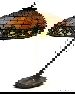 American Leaded Glass Table Lamp with a Unique Art Glass & Metal Co. Base: American Leaded Glass Table Lamp with a Unique Art Glass & Metal Co. Baseearly 20th centuryleaded glass, patinated metal23 1/2 in. high, 19 in. diameter (shade)Provenance: Private Collection, Connecti