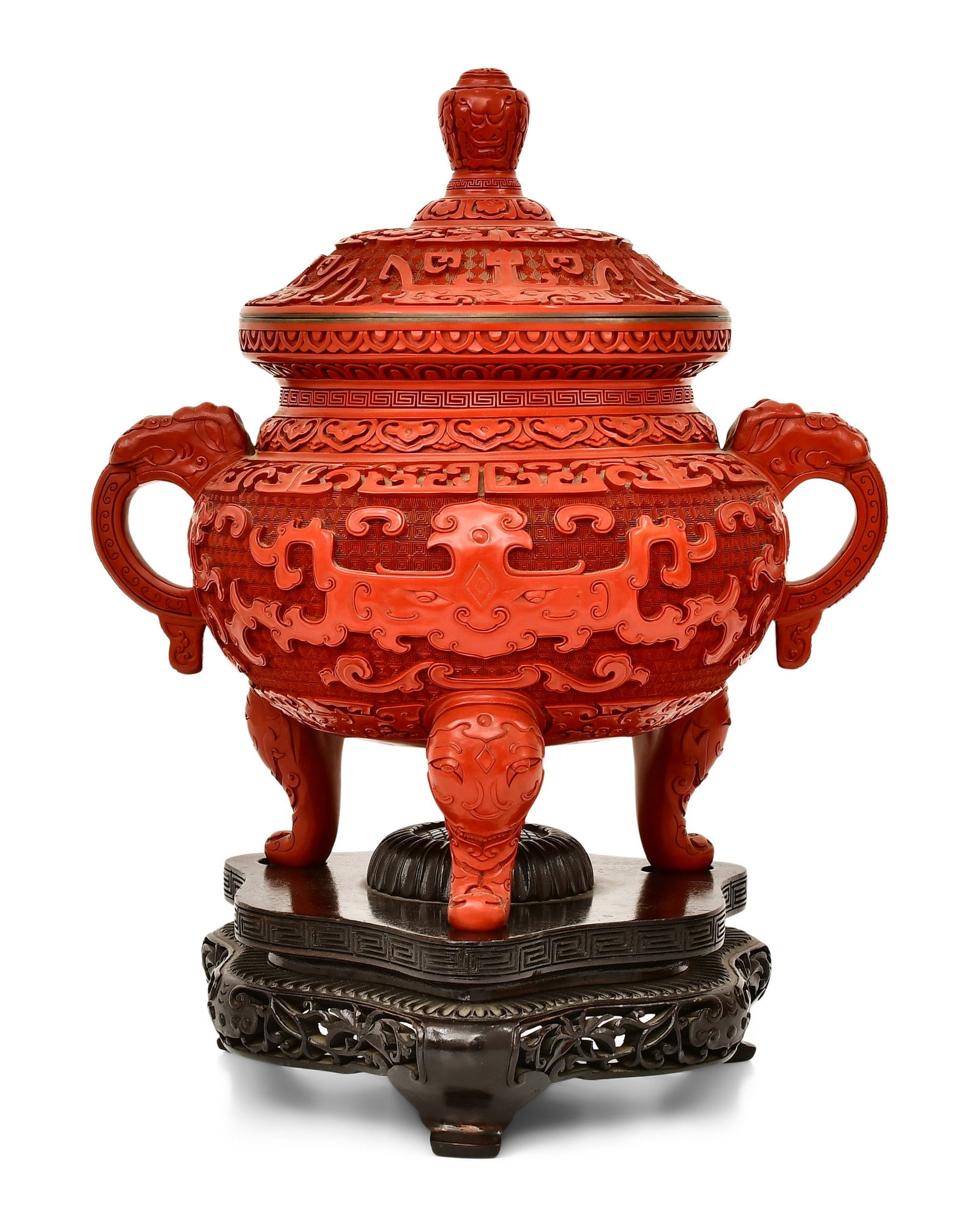 20th Century Chinese Carved Cinnabar Urn: 20th Century Chinese Carved Cinnabar Urndecorated with figural handles and legs, surmounted on a carved wood base19 x 14 x 10 1/2 inchesProvenance: Private Collection, Pennsylvania