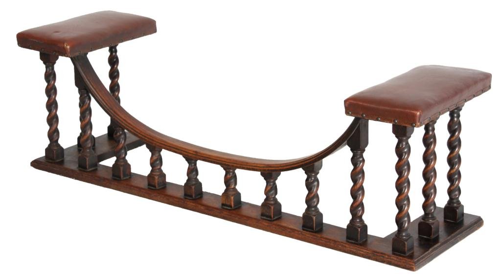 Oak Fire Place Fender Seat: Oak Fire Place Fender Seat. Unusual form with 14 oak spiral turned columns with an concave arched frame and leather padded cushions on either end. in very good condition and original finish; 18 in. hi