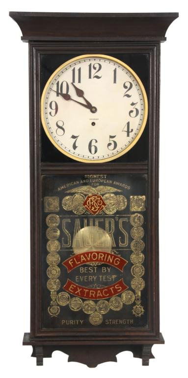 Gilbert University Advertising Wall Regulator: Gilbert University Advertising Wall Regulator. 12 in. paper dial has black Arabic hour numbers, large black spade hands and brass bezel, dial signed Gilbert; 8 day spring driven time only movement has