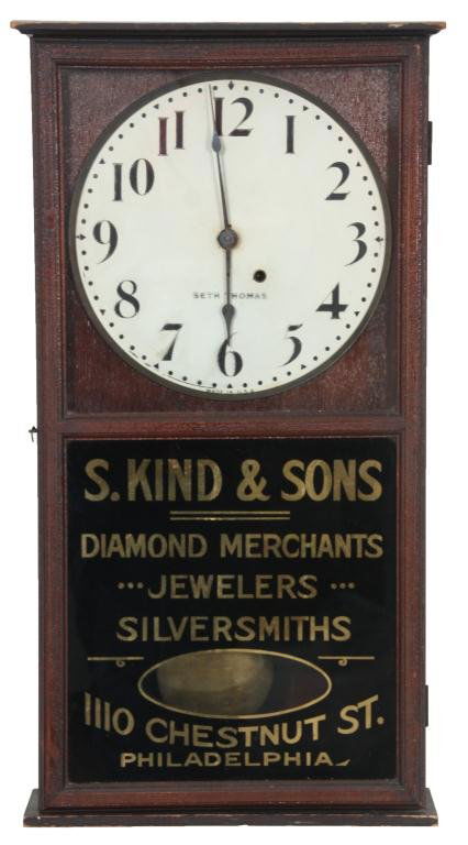 Seth Thomas Advertising Regulator Clock: Seth Thomas Advertising Regulator Clock. 11 in. painted metal dial has black Arabic hour numbers & spade hands, signed Seth Thomas; brass 8 day spring driven time only movement has brass covered pendu