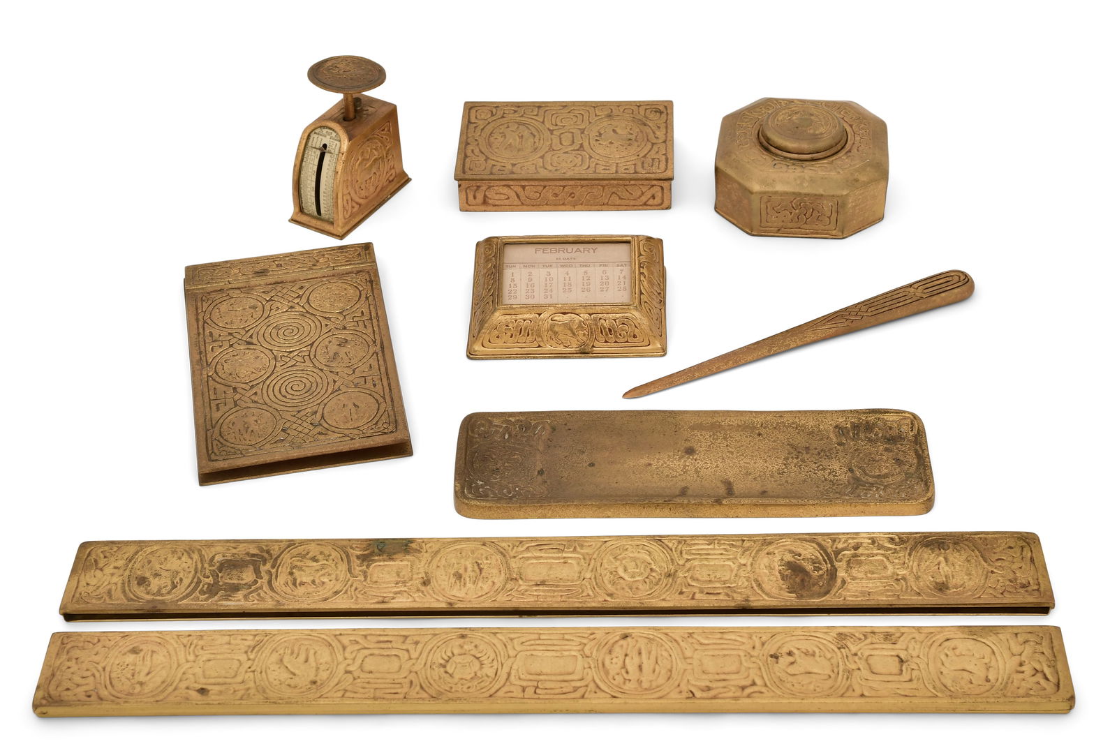 Tiffany Studios "Zodiac" Eight-Piece Desk Set: Tiffany Studios"Zodiac" Eight-Piece Desk Setearly 20th centurybronze, glasscomprising a pair of blotter ends, inkwell with original glass liner, pen tray, notepad holder, letter opener, scale, utility