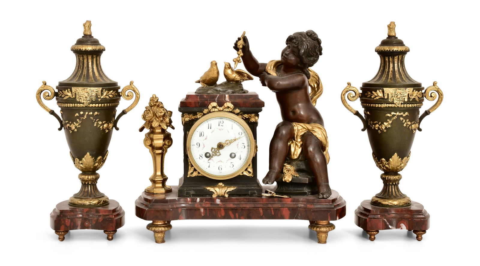 French Bronze & Rouge Marble Clock Garniture: French Bronze & Rouge Marble Clock Garnituremid 19th centurybronze figure of a putti and birds mounted on a red marble base with two matching urns, French ebauche 8-day brass time and strike spring dr
