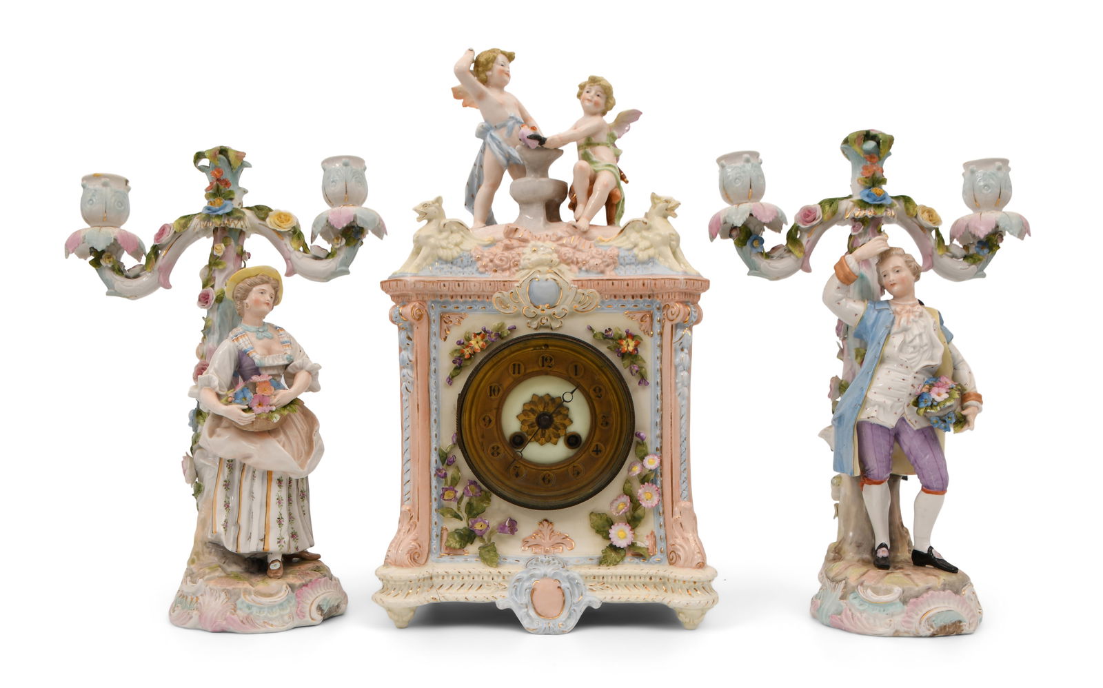 Rudolstadt Porcelain Clock Garniture: Rudolstadt Porcelain Clock Garnitureearly 20th centurythe porcelain clock surmounted by two cherubs, together with two candelabra with a man and woman, brass 8-day movement with gong strike, case sign