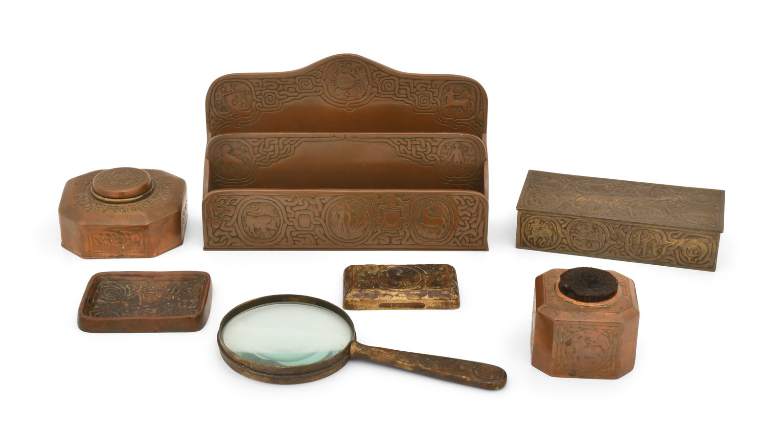 Tiffany Studios "Zodiac" Seven-Piece Desk Set: Tiffany Studios "Zodiac" Seven-Piece Desk Set circa 1910 patinated bronze, glass comprising an inkwell, letter rack, box, ashtray, paperweight, magnifying glass and pen wipe each impressed "Tiffany St