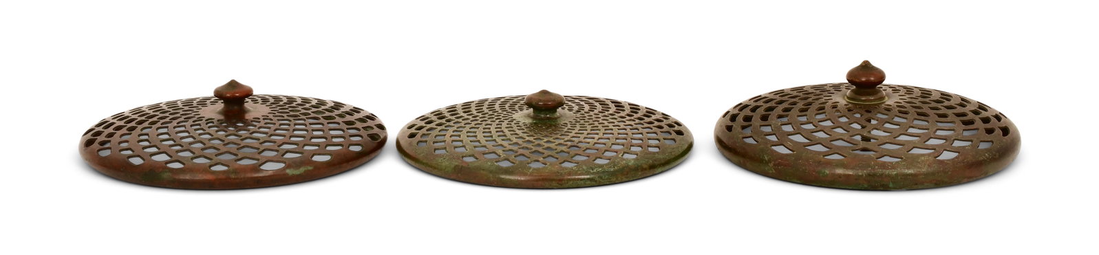 Tiffany Studios, Three Heat Caps: Tiffany Studios Three Heat Caps circa 1910 patinated bronze 4 3/4 in. diameter Provenance: Property from an Important Northeast Collection Other Notes: Fontaine's Auction Gallery can arrange shipping 