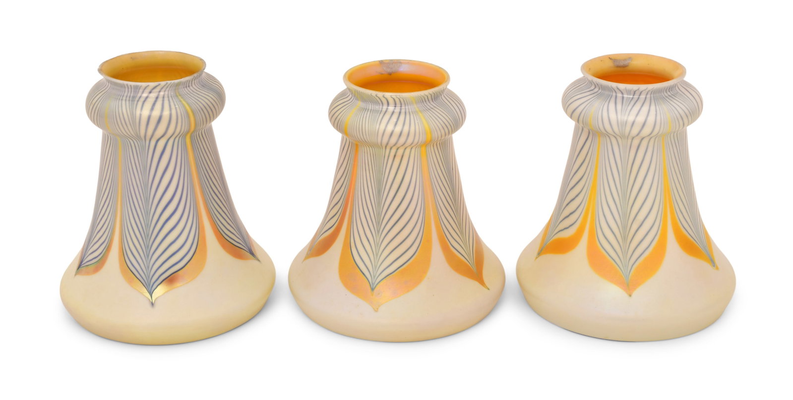 Three Steuben Glass "Pulled Feather" Shades: Steuben Glass Works (Corning, New York, est. 1930) Three "Pulled Feather" Shades early 20th century iridescent glass each signed with fleur-de-lis mark (one partial) 5 x 5 inches Provenance: Privat