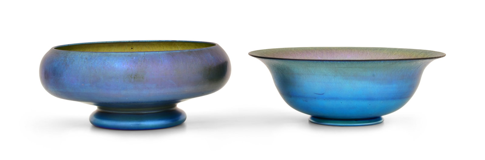 Two Quezal Art Glass Bowls: Quezal Art Glass and Decorating Company (New York, 1901-1924) Two Bowls circa 1915 iridescent glass each marked "Quezal" 4 1/4 x 9 3/4 inches (first) 3 3/4 x 10 1/4 inches (second) Provenance: