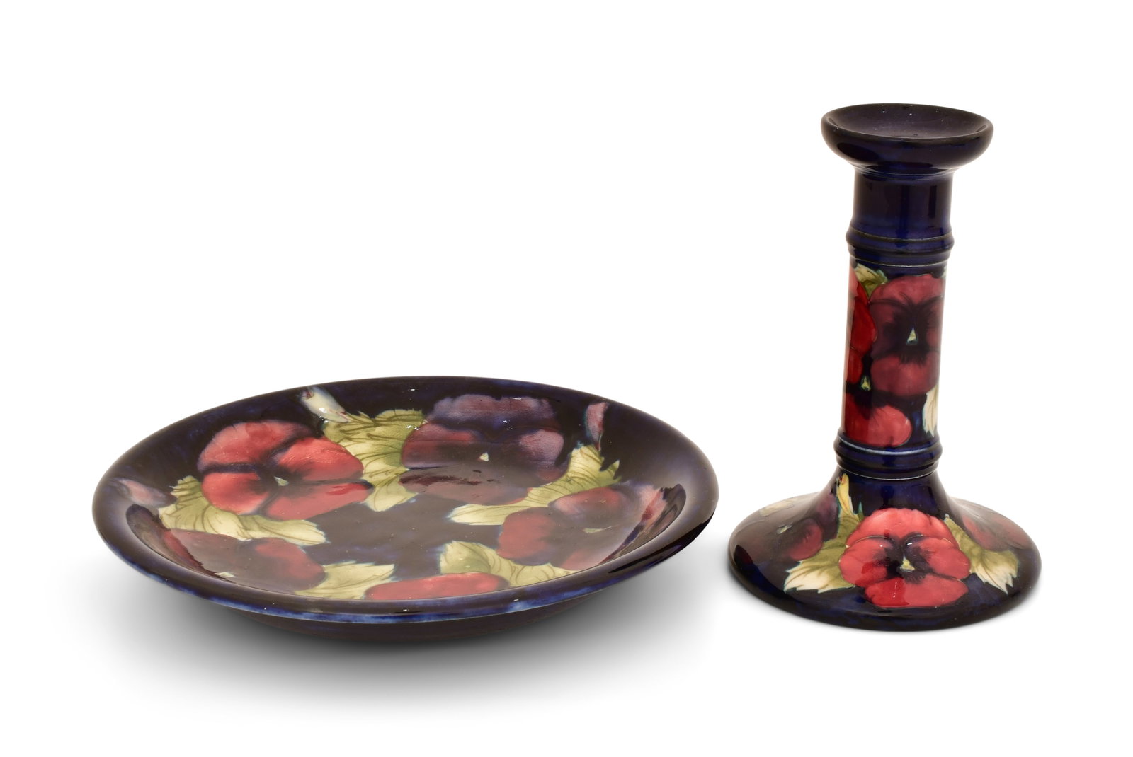 Moorcroft Pottery "Pansy" Plate & Candlestick: Moorcroft Pottery "Pansy" Plate & Candlestick early 20th century each signed to the underside 8 3/4 in. diameter (plate) 6 1/2 x 4 1/4 inches (candlestick) Provenance: Private Collection, Connecticut