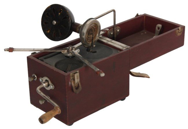 Kameraphone Portable Phonograph: Kameraphone Portable Phonograph. A red canvas covered case with leather handle in the top; the case opens up with a removable tone arm, reproducer and faux tortoise shell speaker, crank and collapsibl