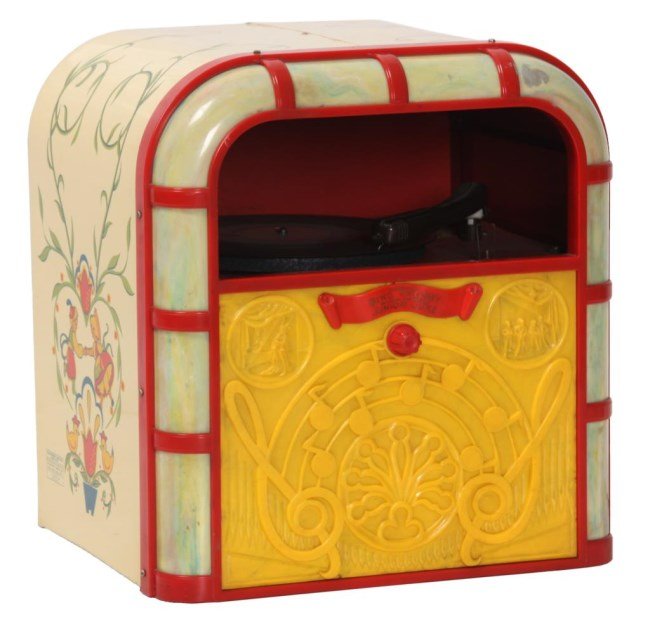 Bing Crosby Junior Juke Model 999: Bing Crosby Junior Juke Model 999. Tin sides painted with filigree and dancing children, the front has red plastic framed with curved light-up plastic bordering the edges and yellow plastic front pane