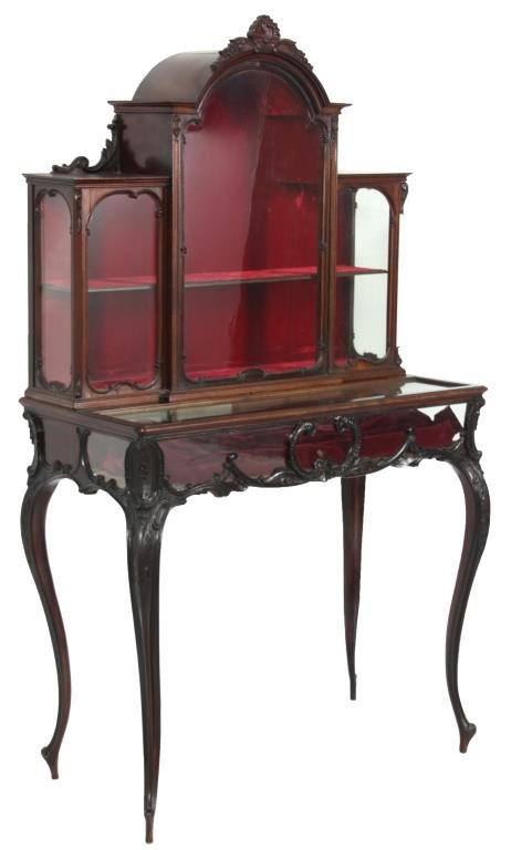 Carved Rosewood Display Cabinet: Carved Rosewood Display Cabinet. A raised center section with arched crest carved with a seashell and filigree with carved corbels at the top of the lower side sections; a single door in the center wi