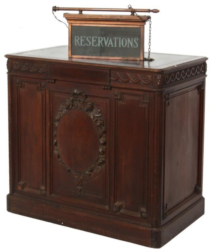 Carved Walnut Receptionist’s Desk w/ Sign: Carved Walnut Receptionist’s Desk w/ Sign. The back side of the desk has 2 banks of 7 drawers and a single center drawer, each having a raised center panel and turned pull; the front of the desk has