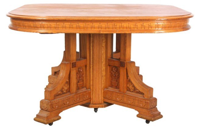 Eastlake Pedestal Base Chestnut Dining Table: Carved Split Pedestal Eastlake Chestnut Dining Table. The 48 in. square top has rounded corners and a carved apron; the split pedestal base has an octagonal center post with 4 carved legs under carved