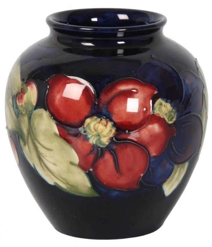 W. Moorcroft Clematis Pattern Vase: W. Moorcroft Clematis Pattern Vase. Tube lined design with a cluster of orange Clematis flowers on a blue background. Vase is in very good condition with no breaks, cracks, chips, hairlines or repairs
