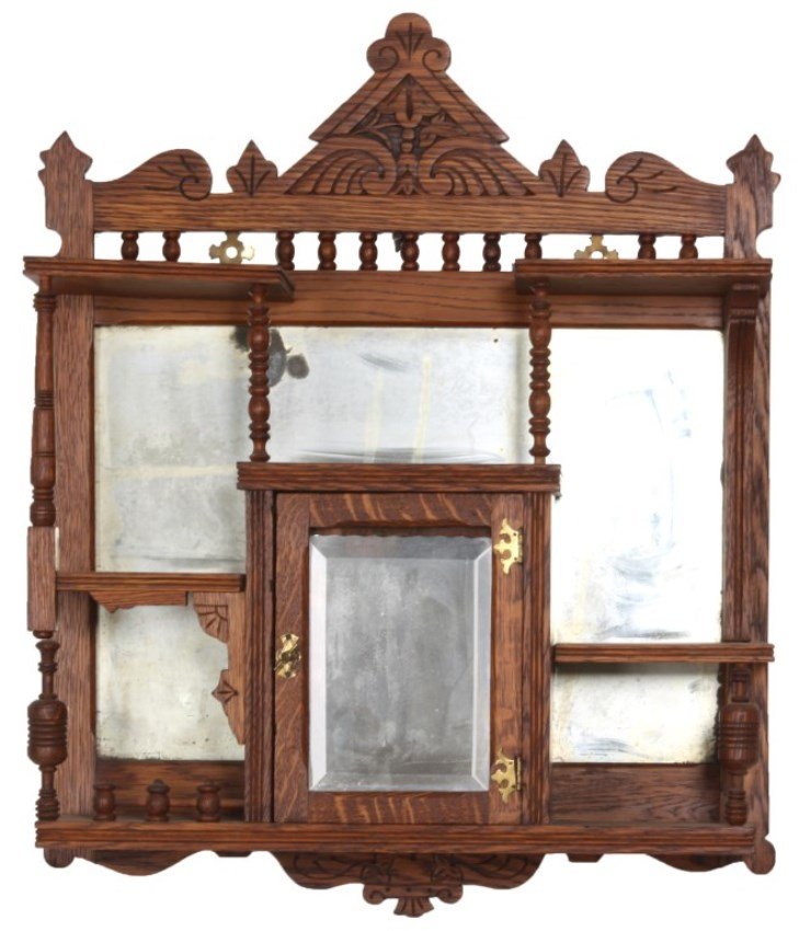 Carved Oak Wall Hanging Cabinet: Carved Oak Wall Hanging Cabinet. Carved crest with spindled gallery, 2 shelves over a mirrored back with center single door compartment, beveled mirror in the door and turned supports. Refinished, bev