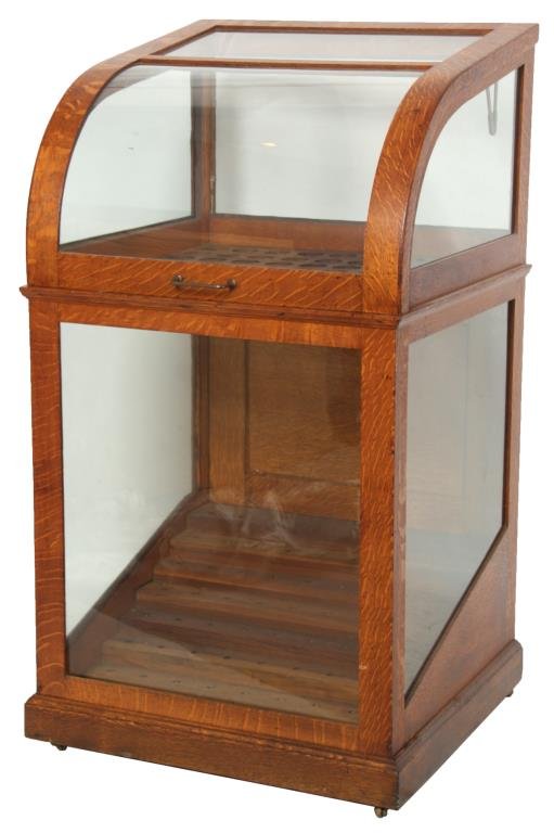 Oak Curved Top Cane Display Case: Oak Curved Top Cane Display Case. Quatersawn oak case has an original golden finish, lift top lid has curved front glass with flat panels on the top, back and sides; a divider inside with 64 individua