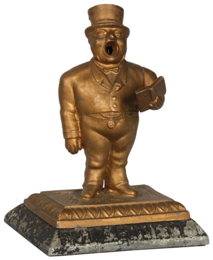 Smoke Fritz Emmett Cigars Cutter: Cast Iron "Smoke Fritz Emmett Cigars" Figural Cigar Cutter, c.1880-1890. Standing figure of a town crier, wearing a suit and top hat, he holds a book out in front of him, by pressing down his arm the