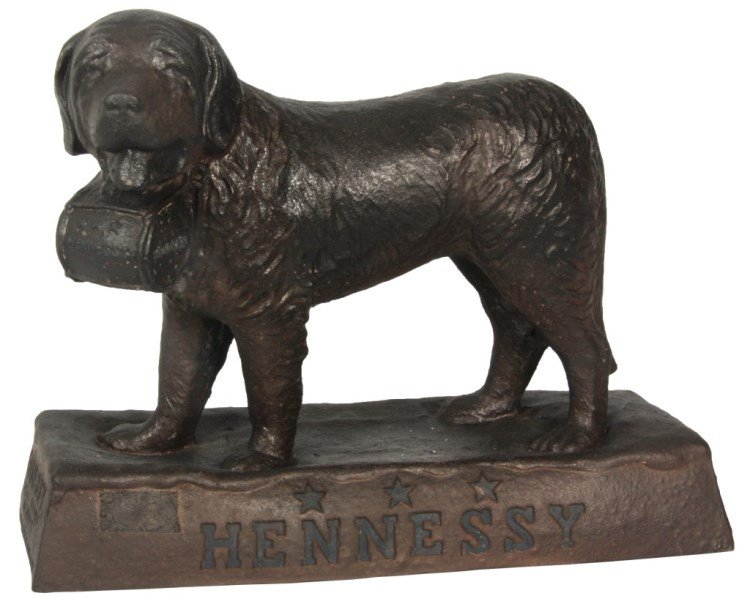 Figural Hennessy Advertising St. Bernard: Figural Hennessy Advertising St. Bernard. Standing composition figure of a St. Bernard with Hennessy keg strapped around his neck; the base resembles snow covered ground and reads Hennessy across the 
