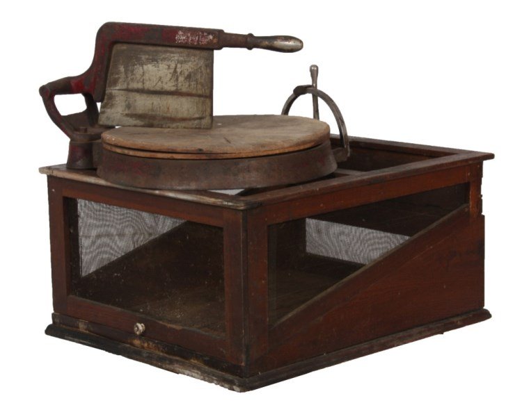 Country Store Cheese Cutter & Display Box: Country Store Cheese Cutter & Display Box. Cast iron frame in original red and silver paint has a large hinged blade with handle, 15.5 in. evolving wood cutting block is turned by a lever on the side