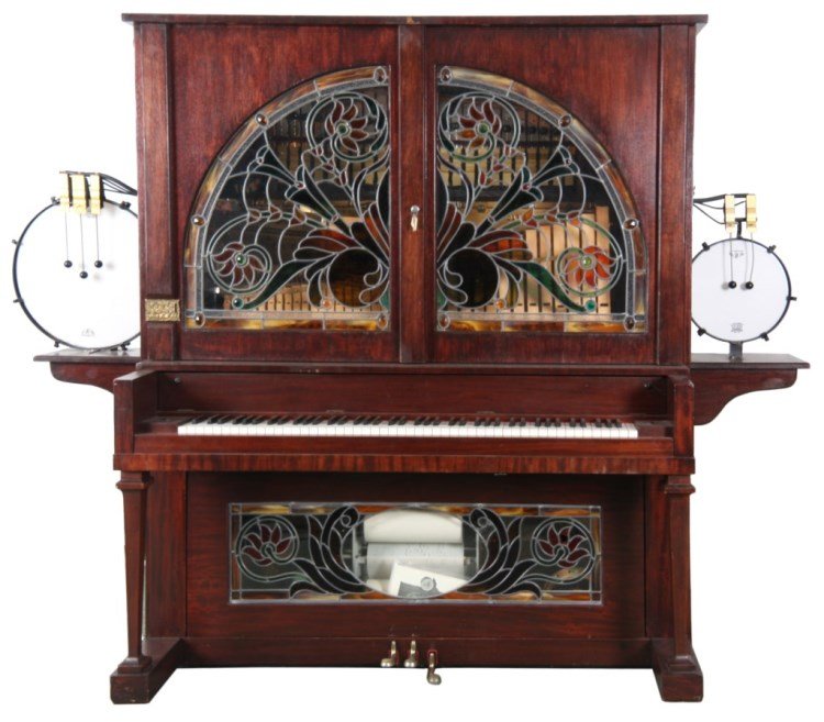 Nickelodeon Coin Op Upright Player Piano: Nickelodeon Coin Op Upright Player Piano Band Organ. Large mahogany upright case with large leaded glass doors in the top and panel in the base with colorful floral and filigree design, has a relief d