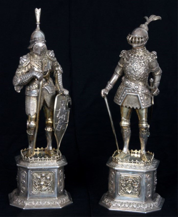 Pr. Sterling Silver Knights: Pr. Sterling Silver Knights. Hand chased sterling silver standing knight figures in full armor with shields, swords and one with battle axe, standing on a tall repousse decorated plinth. Marked German