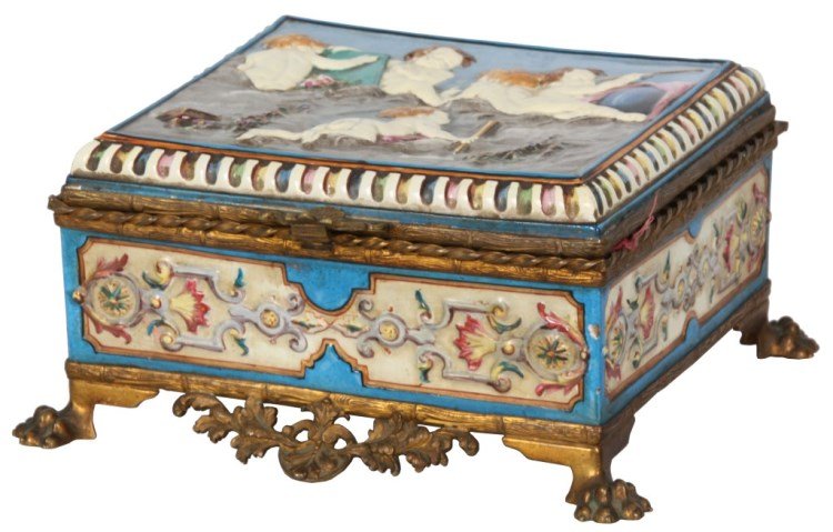 Porcelain & Brass Mounted Jewelry Box: Relief Decorated Porcelain & Brass Mounted Jewelry Box. Hinged box has a relief decorate lid with 5 figural putti, the sides have fancy filigree decorated panels and a blue background; fancy brass mou