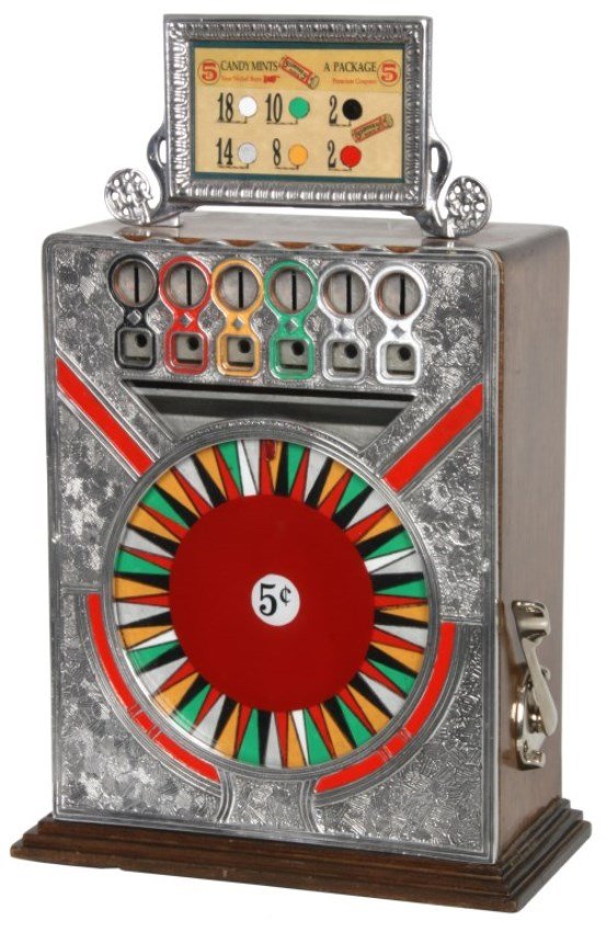 5 Cent Coin Op Game Wheel Trade Stimulator: 5 Cent Coin Op Game Wheel Trade Stimulator. Oak case with cast front, has an 8 in. spinning game wheel under 6 color coded coin selector slots and a chrome banner at the top; the machine dispenses a f